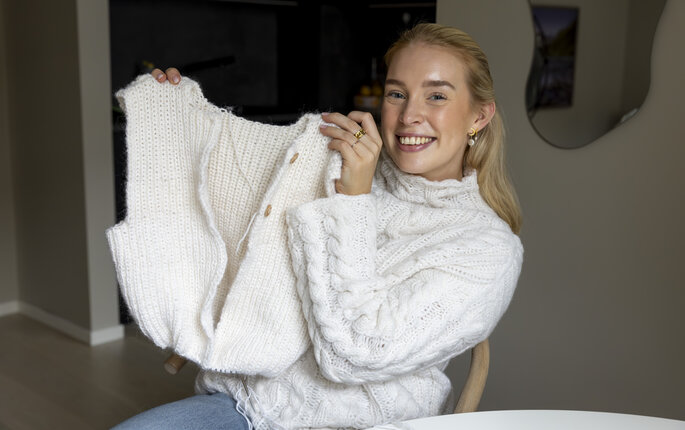 Bildet viser Maria Tessem som holder opp en påbegynt vest.