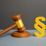 Bildet viser en dommerklubbe og en paragraf