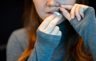 Bildet viser en ung kvinne som legger inn en pris snus.