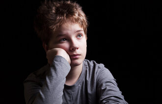 Bildet viser en trist gutt.