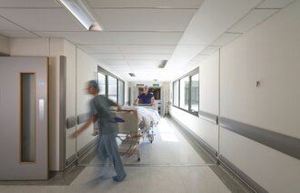 Bildet viser helsearbeidere som triller en seng.