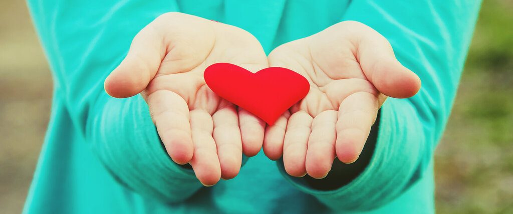 Bildet viser to hender som holder et hjerte