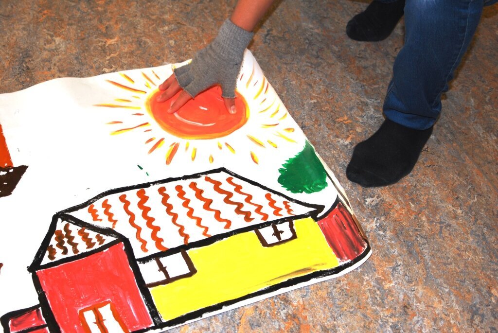 Gjennom kunst, drama, musikk og andre øvelser får unge asylsøkende gutter hjelp til å finne håp og trygghet i tilværelsen. Bildet viser et maleri av et hus og sol, og en hånd lagt over sola.