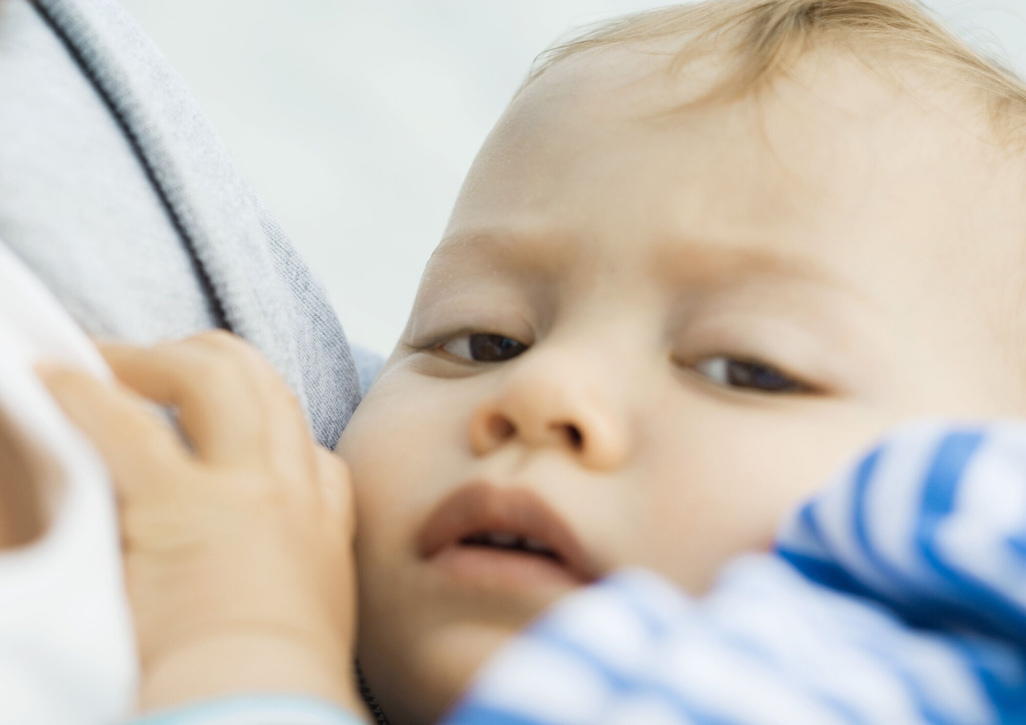 Liten gutt Illustrasjonsfoto av et lite barn som bæres inntil en voksen