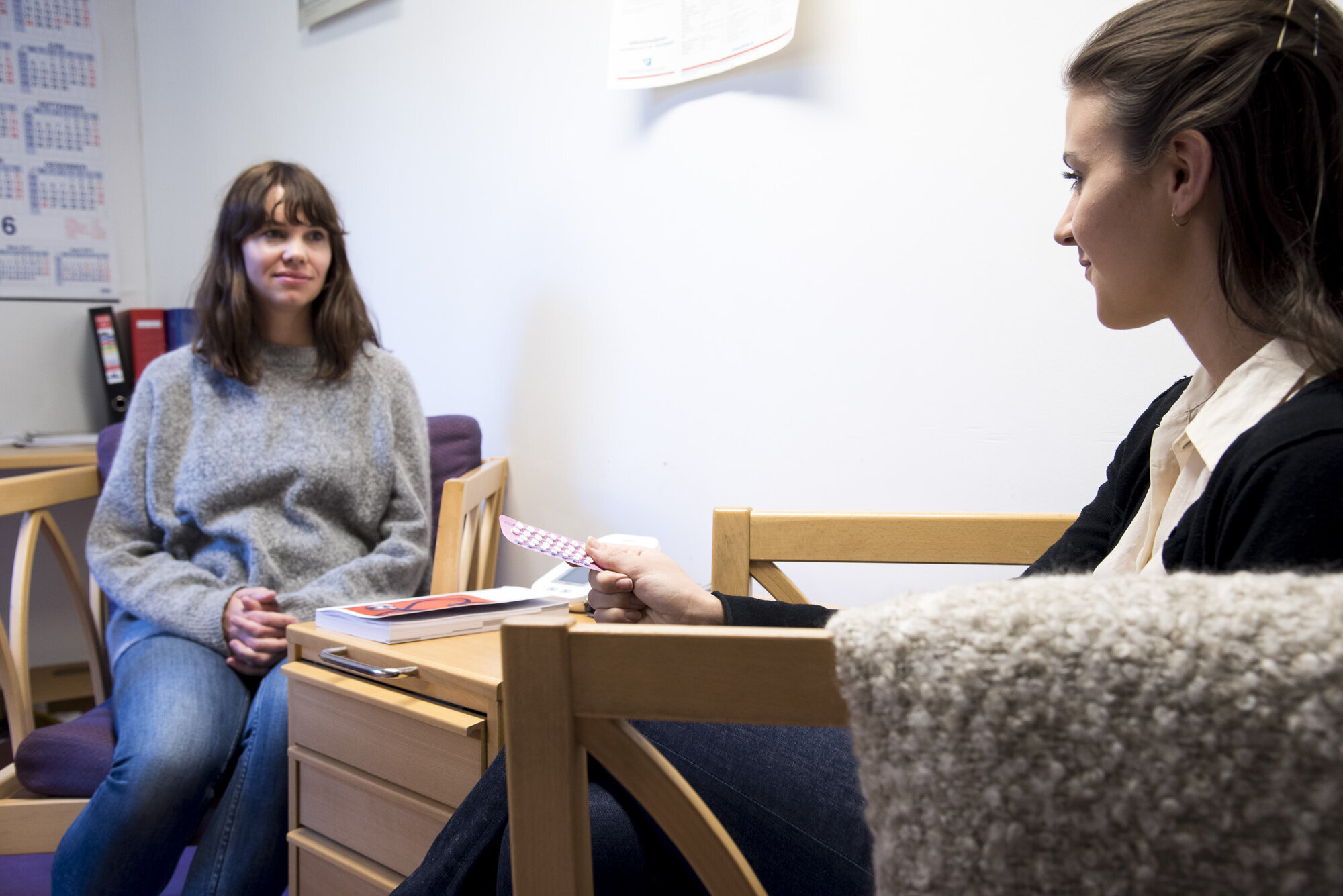 Ung jente, helsesøster, p-piller Bildet viser en ung jente som holder et p-pillebrett hos helsesøster.