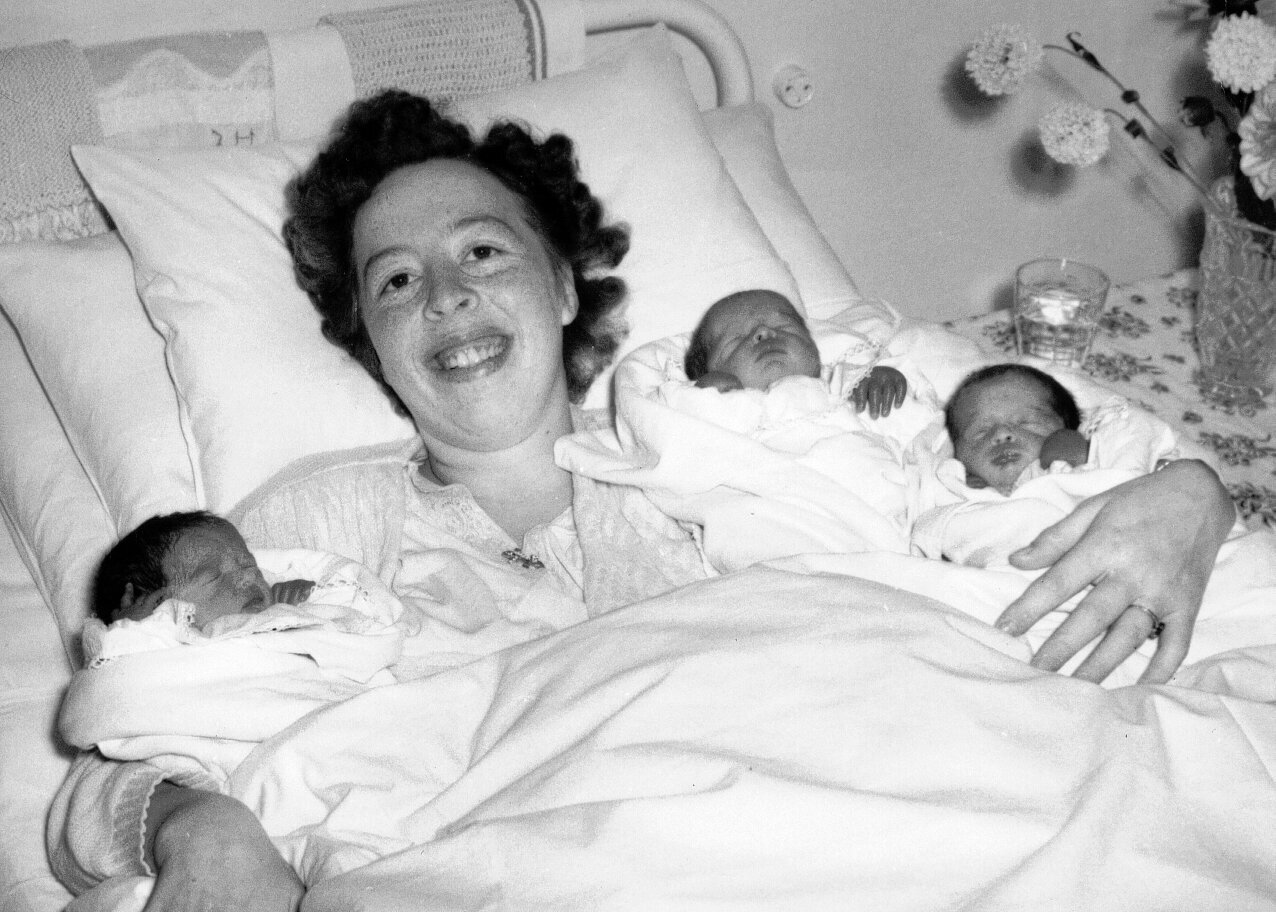 Nybakt mor med trillinger Bildet viser en nybakt mor med trillinger etter hjemmefødsel