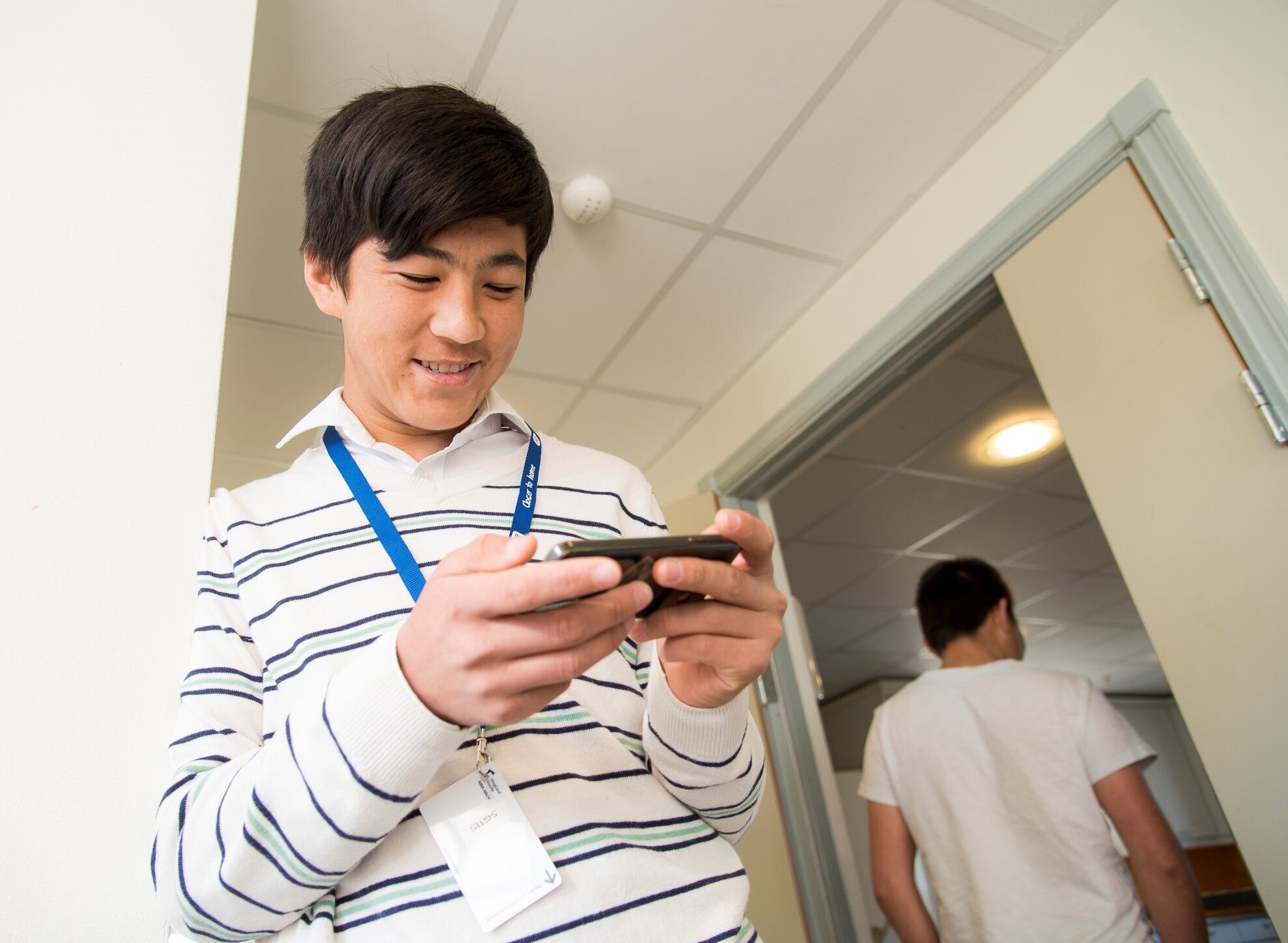 Rahimi spiller fotball på mobilen Bildet viser Rahimi