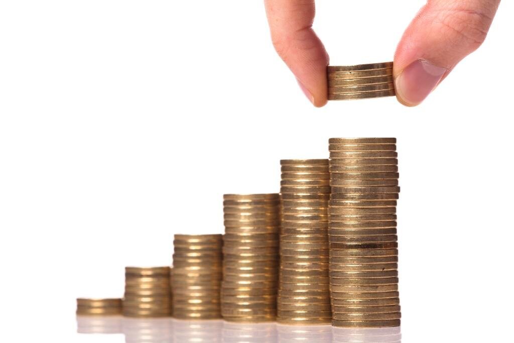 Rådmann i Porsgrunn, Per Wold, forsvarer kommunens lønnspolitikk. Bildet viser to fingre som løfter noen mynter fra en stabel.