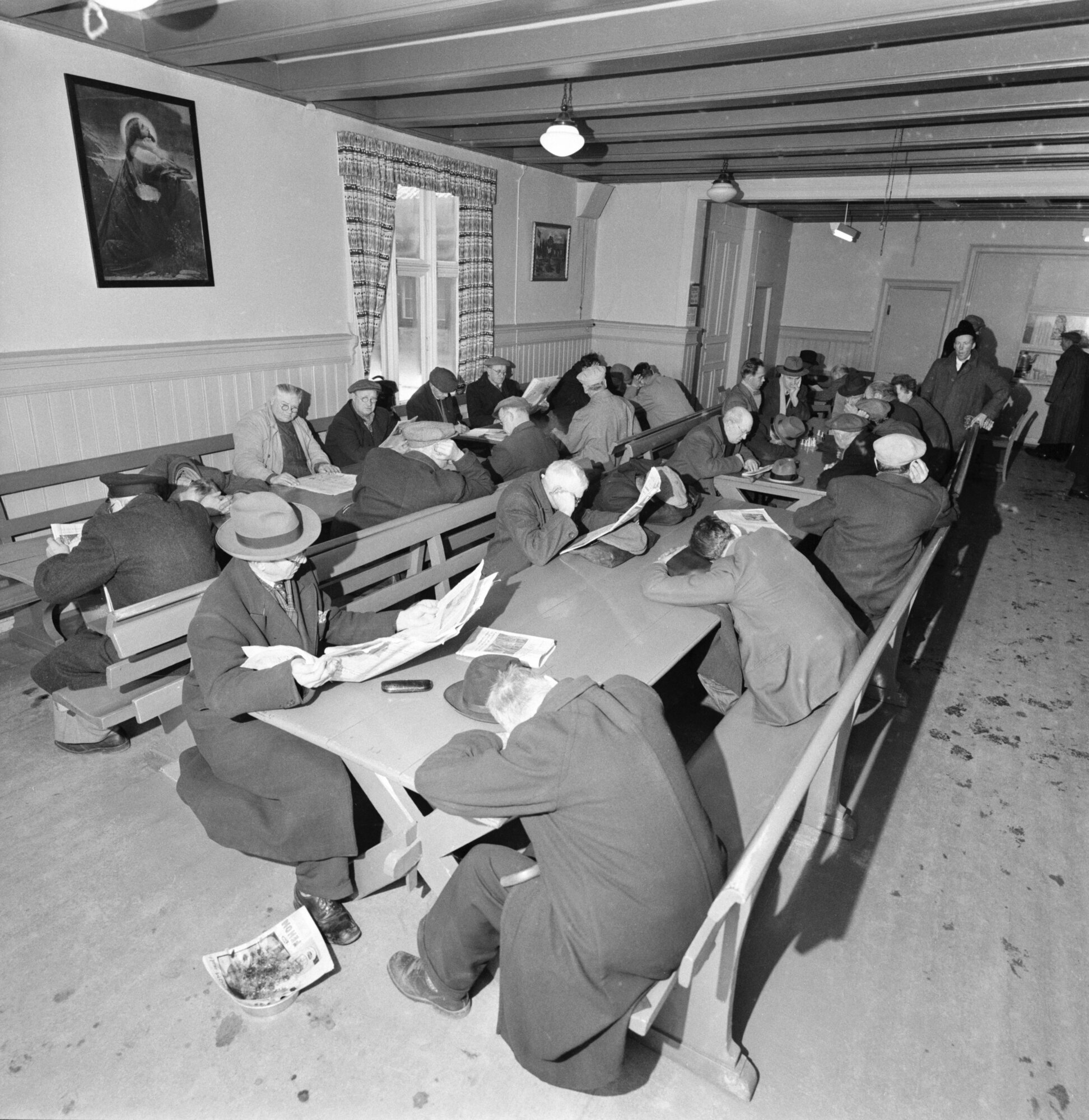 Hjemløse menn i Oslo hadde Indremisjonens varmestue i Møllergata å ty til, når de trengte å få varme i kroppen på dagtid i 1957. Bildet viser varmestuen til Indremisjonen.