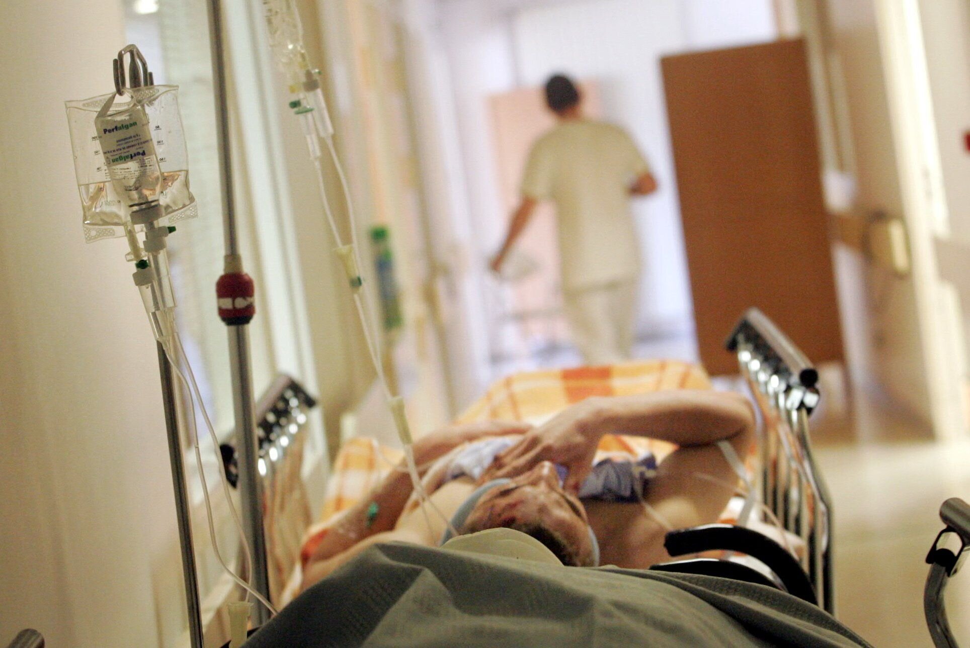 Sykehus Korridorbilde fra sykehus hvor det ligger en pasient. Helsepersonell går bortover