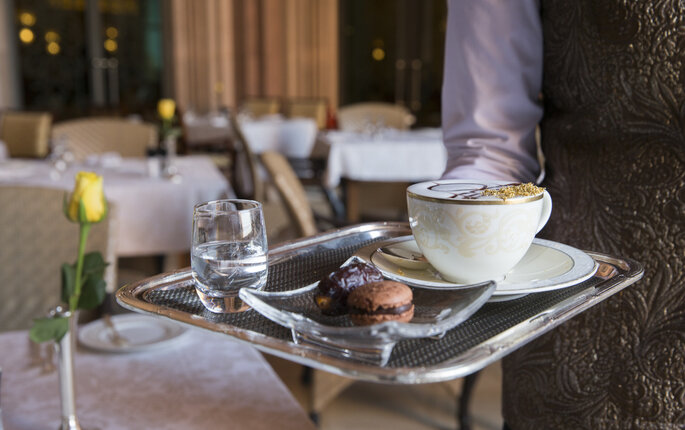 Bildet viser en servitør som serverer kaffe.