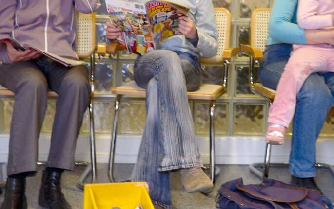 Bildet viser bena til pasienter som sitter på venterom Bildet viser bena til pasienter som sitter på venterom