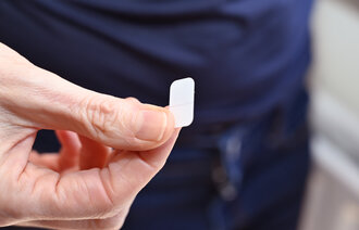 Bildet viser en hånd som holder et lite plaster.