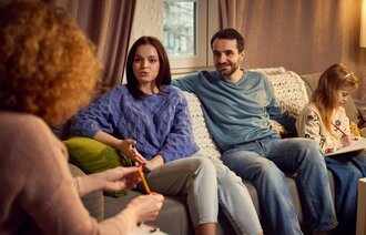 Bildet viser en barnekoordinator som snakker med en familie