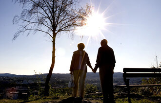 Bildet viser skyggene av to eldre mennesker som holder hender.