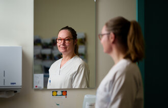 Bildet viser Lise Tuset Gustad som ser seg i et sykehusspeil.