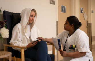 Bildet viser en ung voksen pårørende og en sykepleier